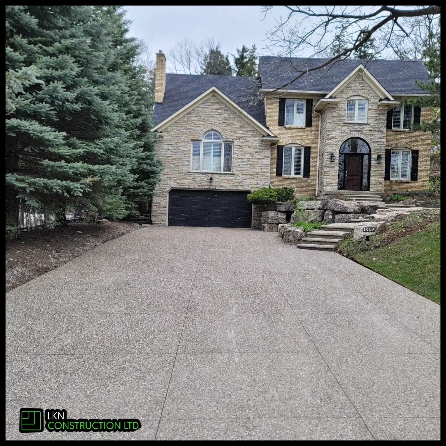 Concrete driveway at stone home