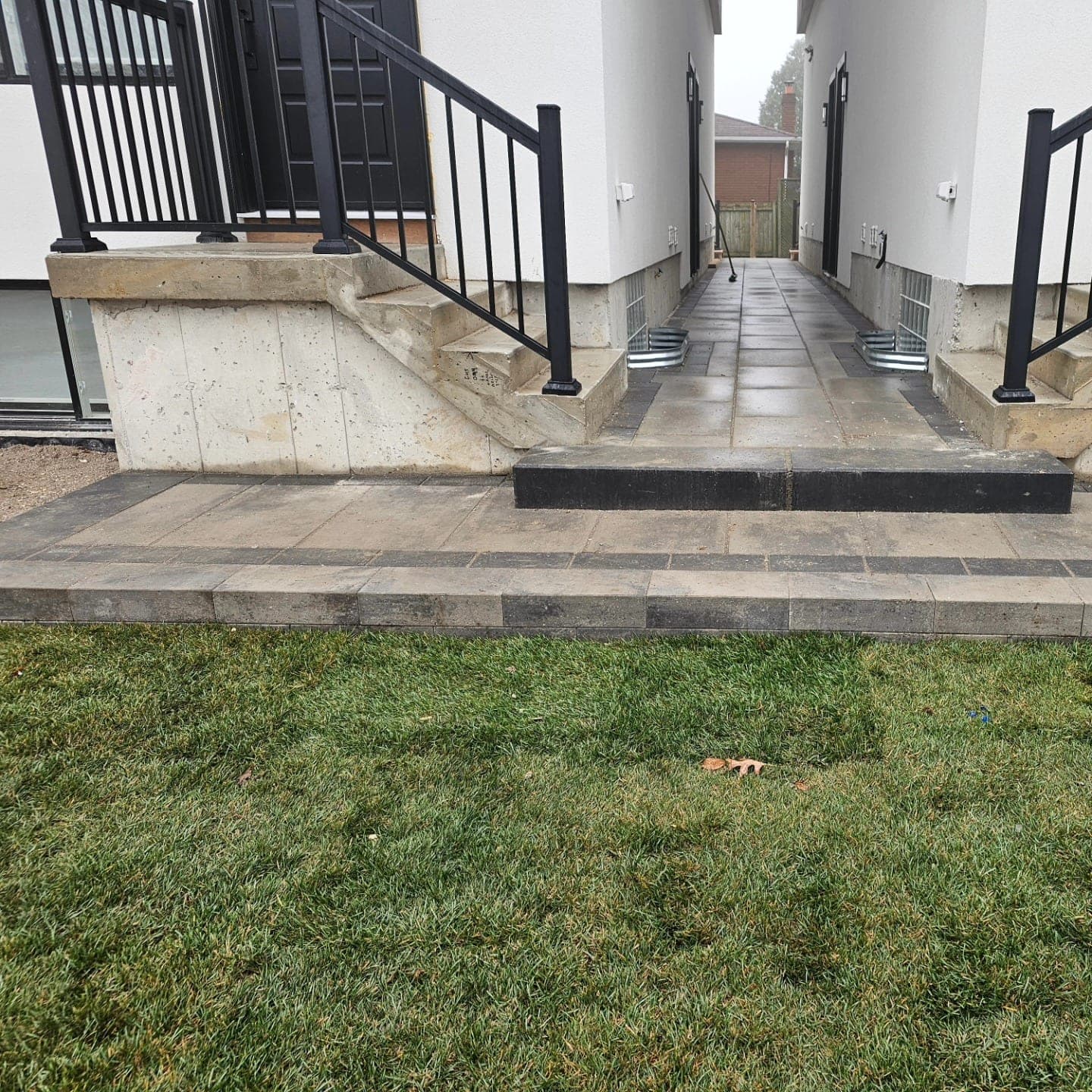 Paver walkway with cedar framing between two homes