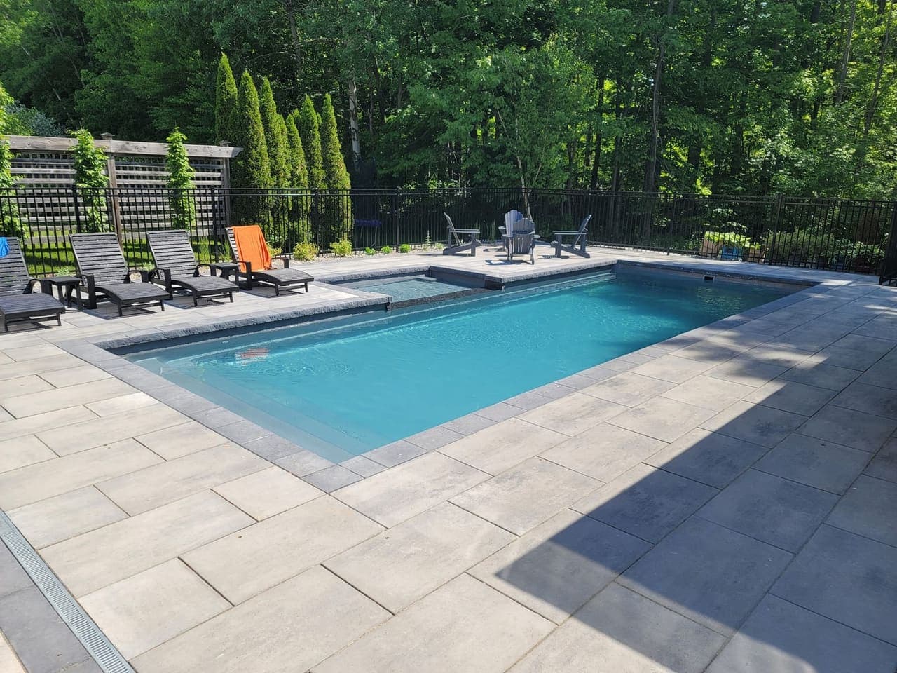Inground pool surrounded by large-format interlock pavers by LKN Construction